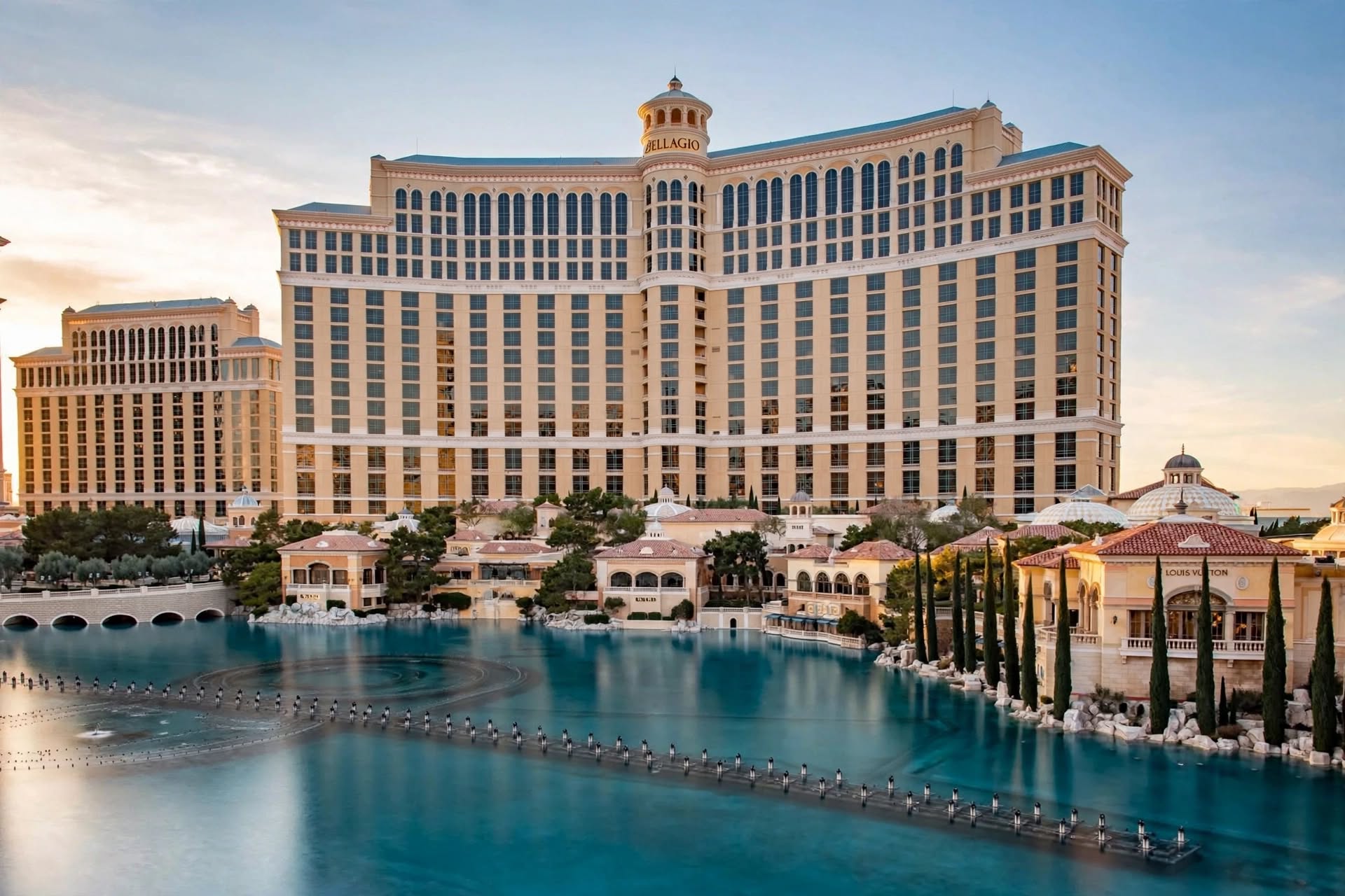 Sunlit view of Bellagio hotel facade reflecting across the iconic grand lake in Las Vegas