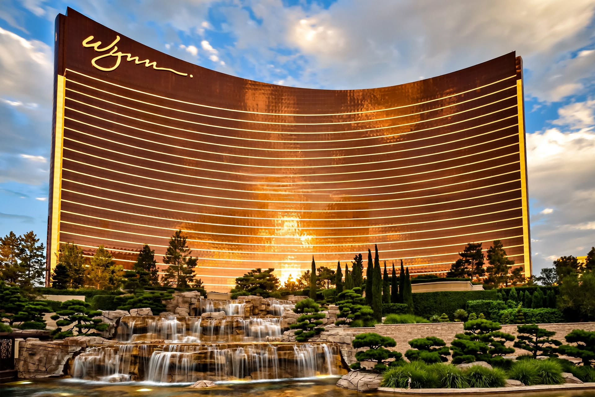 Curved bronze glass facade of Wynn Las Vegas rising above garden landscaping